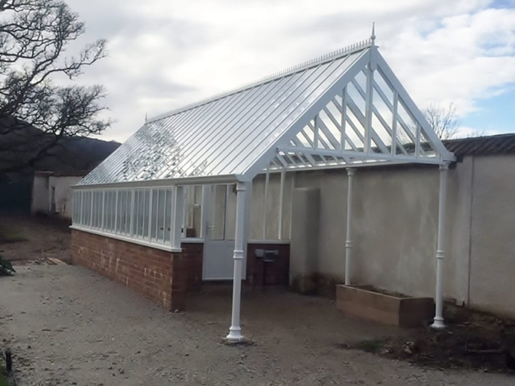 Bespoke aluminium greenhouse with extended front roof in Devon
